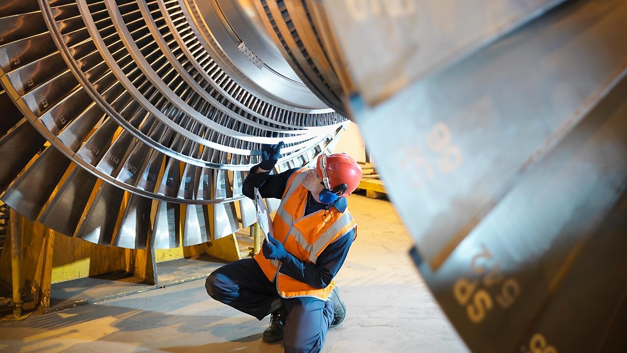 Worker inspects turbine in power station