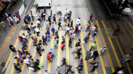 People cross a busy street in Hong Kong