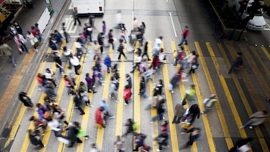 People cross a busy street in Hong Kong