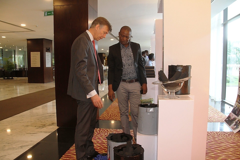 The Charcoal Alternative Champion showing Managing Director of Shell Tanzania Mr. Marc den Hartog the displayed alternative charcoal which he produces and the special stoves for the charcoal seen in the picture during the exhibition at the Stakeholders Roundtable event. 