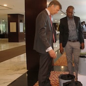 The Charcoal Alternative Champion showing Managing Director of Shell Tanzania Mr. Marc den Hartog the displayed alternative charcoal which he produces and the special stoves for the charcoal seen in the picture during the exhibition at the Stakeholders Roundtable event. 