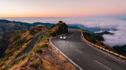 Car driving with headlights on a coastal route