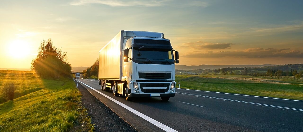 businessman overseeing three parked lorries