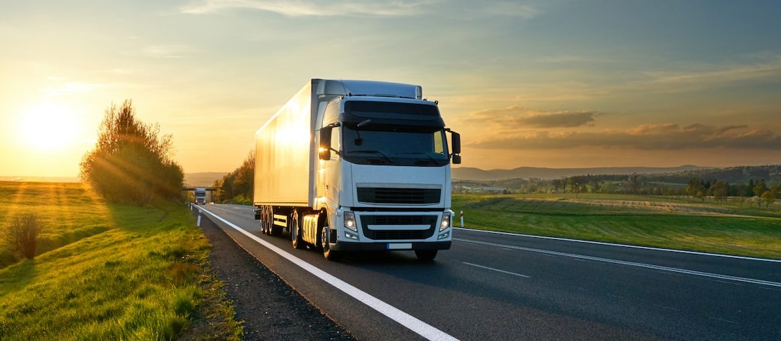 businessman overseeing three parked lorries